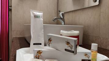 A bathroom sink with a shaving kit, soap, and shampoo.