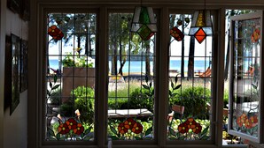 A room with a view of the sea through a window with stained glass.