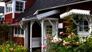 A traditional red and white building with a white porch and a sign that reads "Amann's Bar & Restaurant."