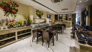 A restaurant with marble flooring, multiple dining tables, chairs, and a variety of bowls and plates displayed on shelves. - Roseland Sweet Hotel (Ho Chi Minh City)