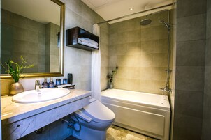 A modern bathroom with a sink, mirror, and a shower area.