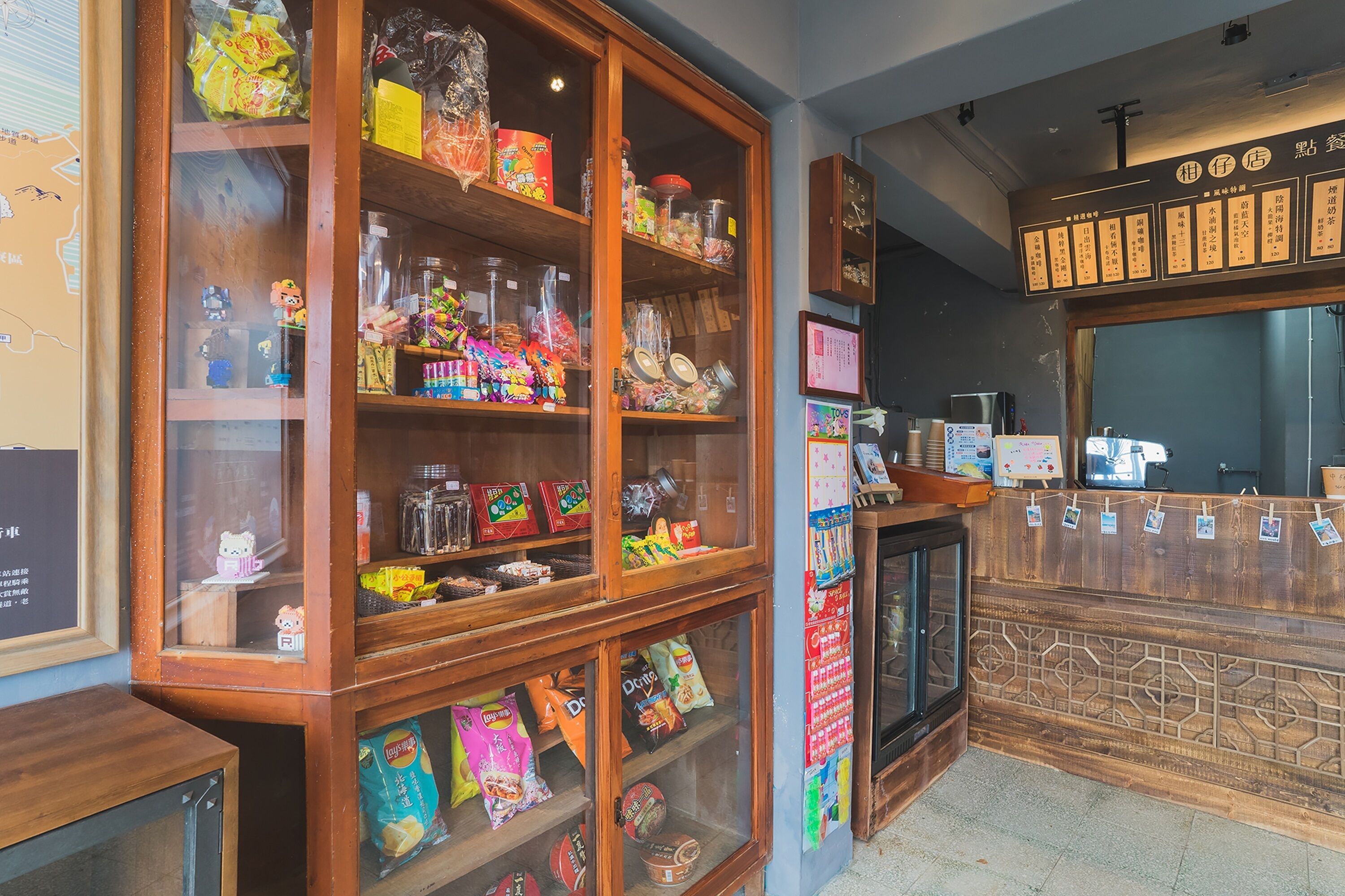 A candy store with wooden display cases filled with various snacks and a menu board above the counter.
