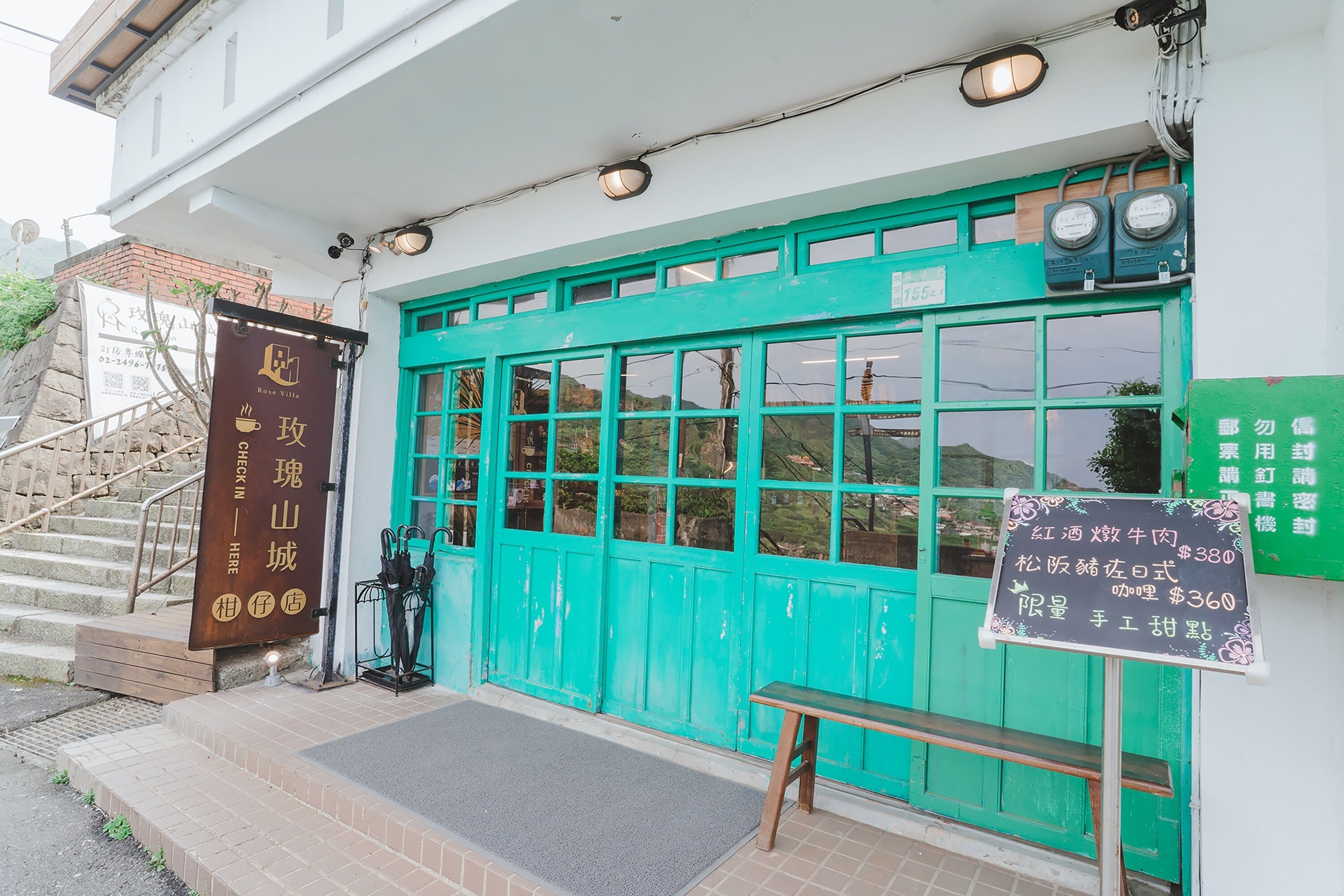 A building with a green door and a signboard.
