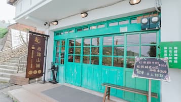 A building with a green door and a signboard.