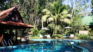 Una piscina al aire libre, tumbonas