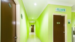 A hallway with green walls, a brown door labeled "KELUAR EXIT", and a sign indicating "KELUAR". - Super OYO 443 Crystal City Hotel (Kuantan)