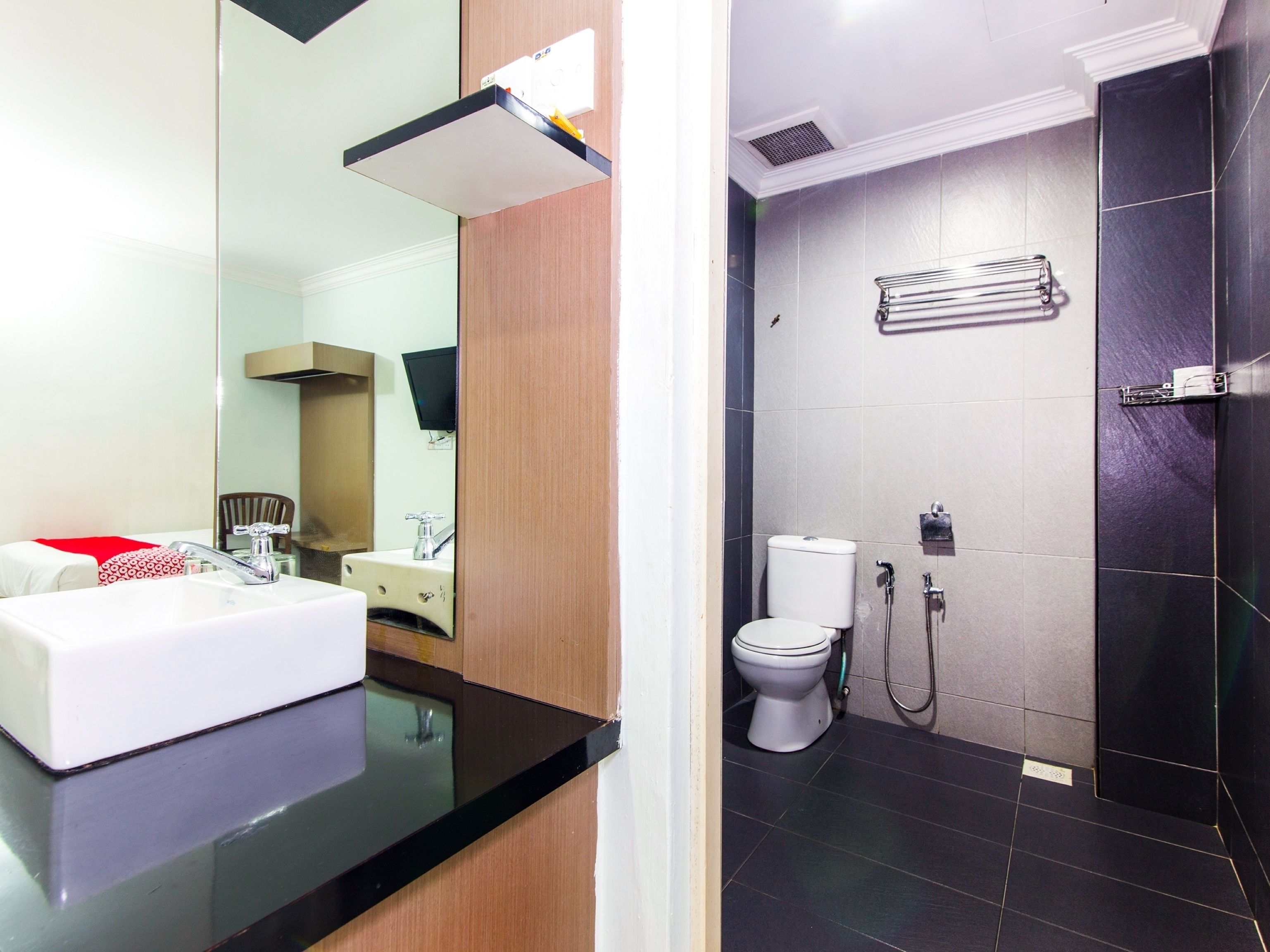 A bathroom with a white sink, mirror, and toilet.