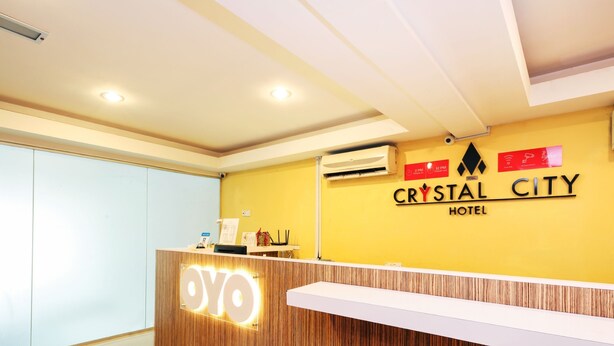 A hotel reception desk with a wooden finish and a sign that reads "Crystal City Hotel". - Super OYO 443 Crystal City Hotel (Kuantan)