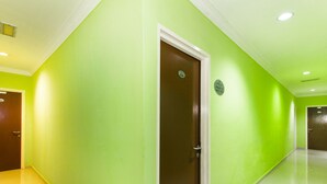 A hallway with green walls and a brown door. - Super OYO 443 Crystal City Hotel (Kuantan)