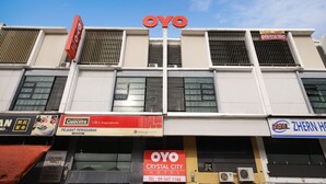 A building with multiple businesses including a hotel named 'Crystal City Hotel' with a contact number. - Super OYO 443 Crystal City Hotel (Kuantan)