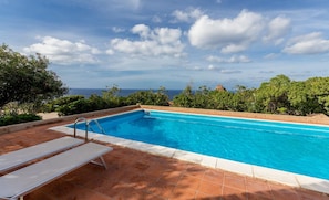 Una piscina rettangolare con acqua cristallina, circondata da un bordo piastrellato.