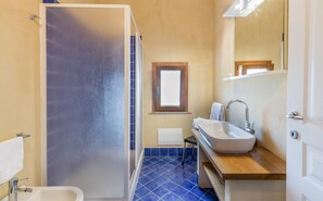 A bathroom with a shower, sink, and a window. - Villa La Bitta (Badesi)