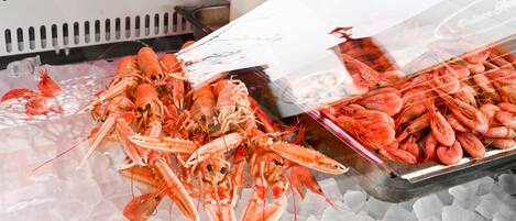 Exhibición de langostas cocidas sobre hielo en un mercado de mariscos.