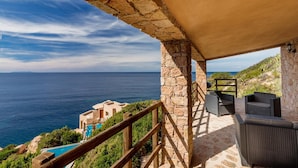 A stone balcony with outdoor seating overlooking a coastal view. - Villa Saluto del Sole (Trinità d'Agultu e Vignola)