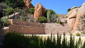 A stone staircase leading up to a rocky outcrop with a metal railing. - Villetta Ambra Rossa (Trinità d'Agultu e Vignola)