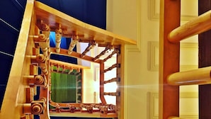 A wooden spiral staircase with a mirrored wall reflecting the room. - Belizia Hotel (Istanbul)
