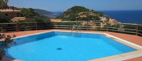 A rectangular swimming pool with a clear blue water surface, surrounded by a tiled deck.