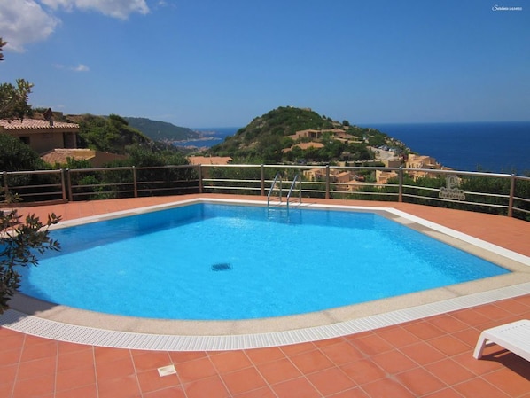 A rectangular swimming pool with a clear blue water surface, surrounded by a tiled deck.