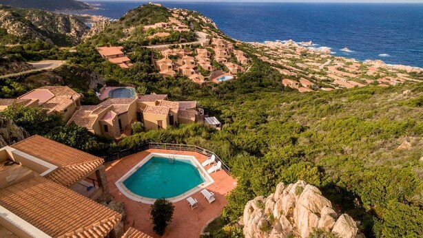 A resort with terracotta-roofed buildings, a swimming pool, and a view of the sea. - Casa Rosa Quattro (Trinità d'Agultu e Vignola)