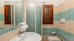 A bathroom with a large sink, a toilet, a bidet, and a shower enclosure. - Casa Rosa Quattro (Trinità d'Agultu e Vignola)