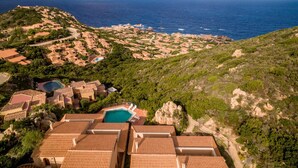 A coastal resort with terracotta-roofed buildings, a swimming pool, and views of the sea. - Casa Rosa Due (Trinità d'Agultu e Vignola)