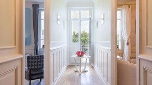 Un couloir doté d’un plancher en bois, de lambris blancs et d’un lustre.