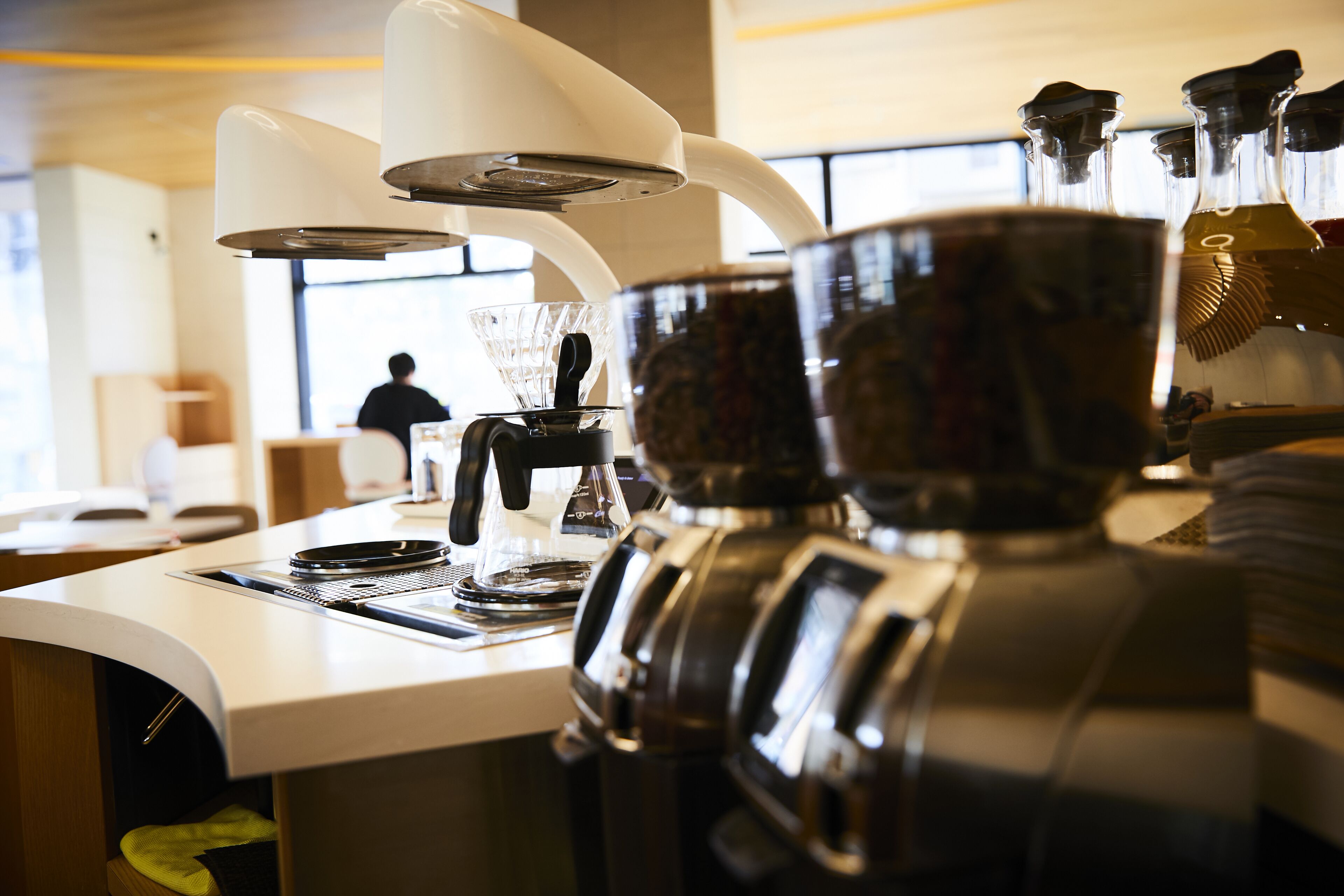 Une machine à café dotée d’une buse vapeur et d’un pichet pour faire mousser le lait, ce qui indique qu’il s’agit d’un modèle conçu pour un bar à café.