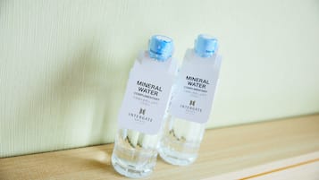 Two bottles of mineral water labeled 'Mineral Water' and 'Complementary' on a wooden surface.