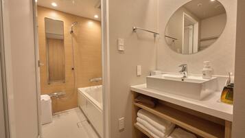 A modern bathroom with a bathtub, a shower, a sink, and a mirror.