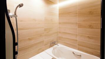 Une salle de bain avec une baignoire, une douche et des toilettes.