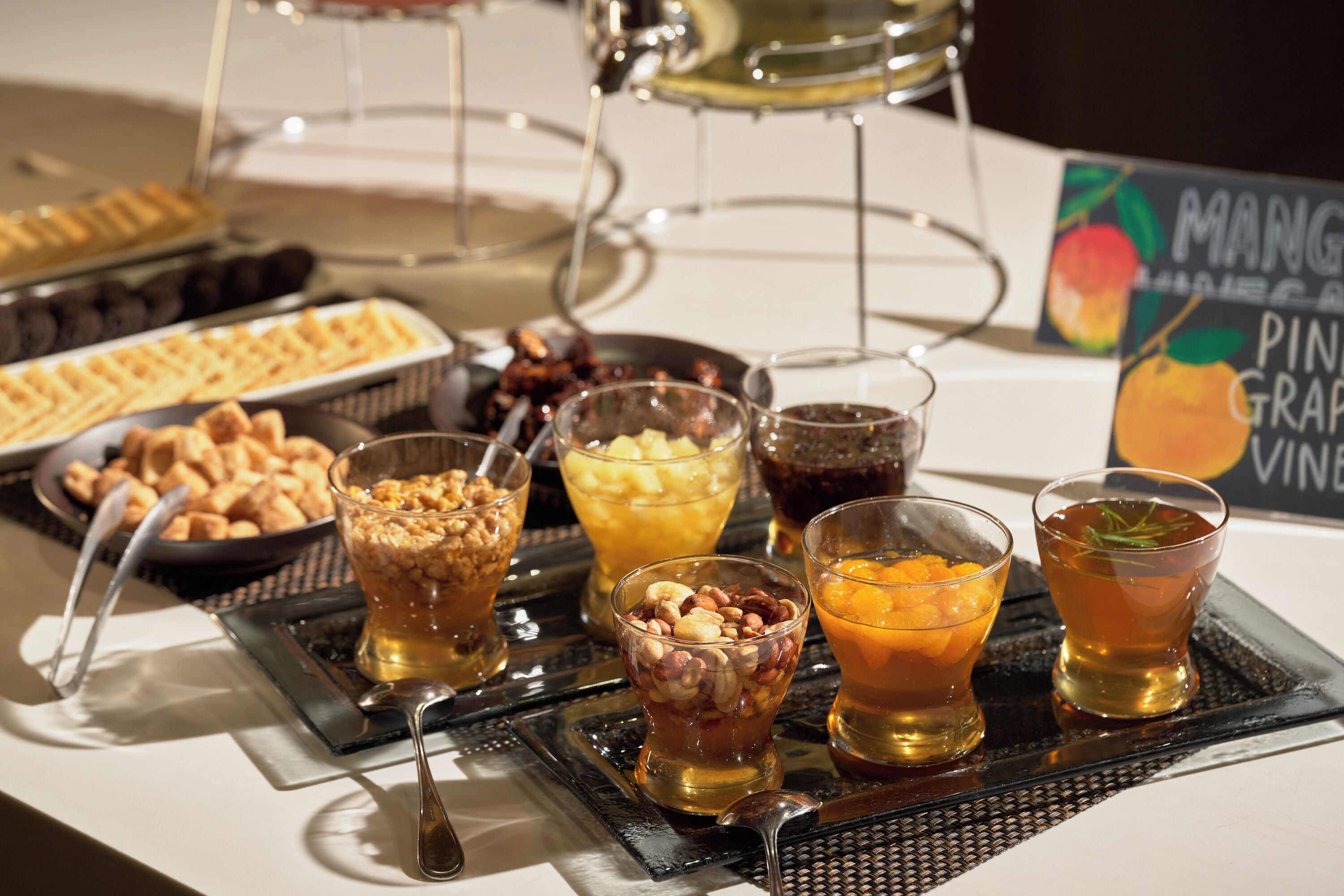 A buffet table with various food items and drinks.