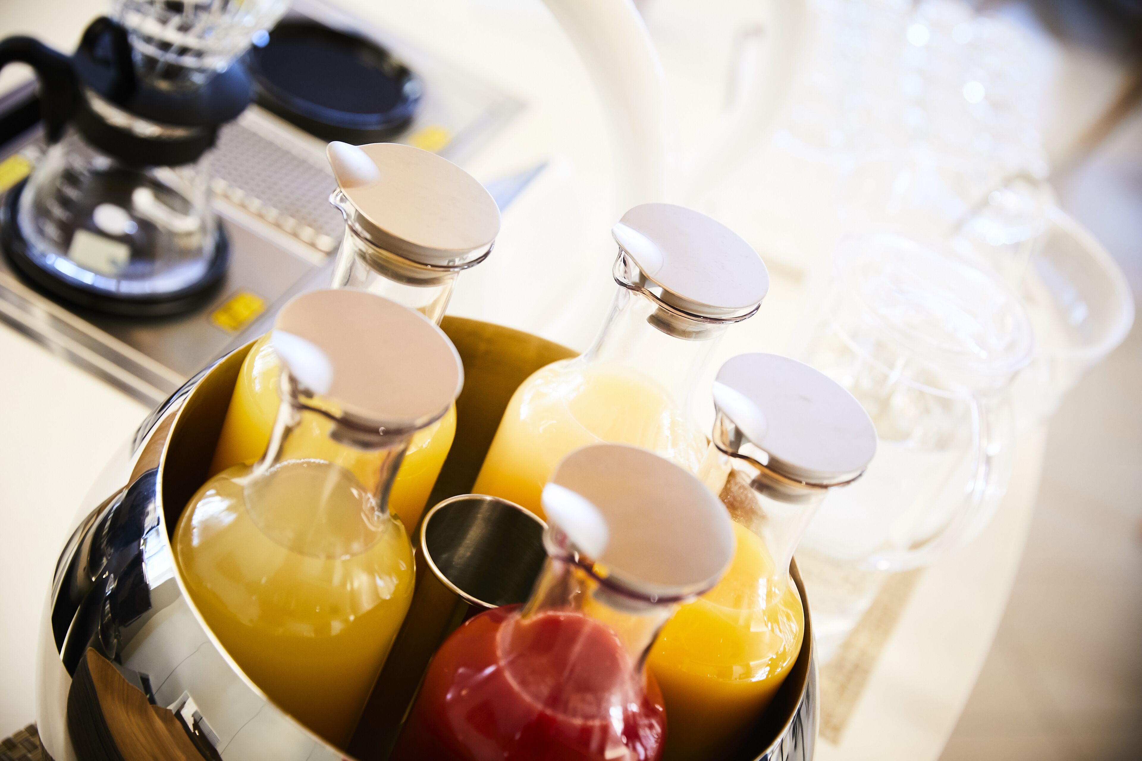 A stainless steel container holding various bottles with lids, likely containing beverages.