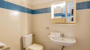 A bathroom with a toilet, sink, and mirror. - Villetta Ginepro Rosso (Trinità d'Agultu e Vignola)