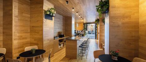 A modern interior with wooden flooring and walls, a central bar area, and seating arrangements.