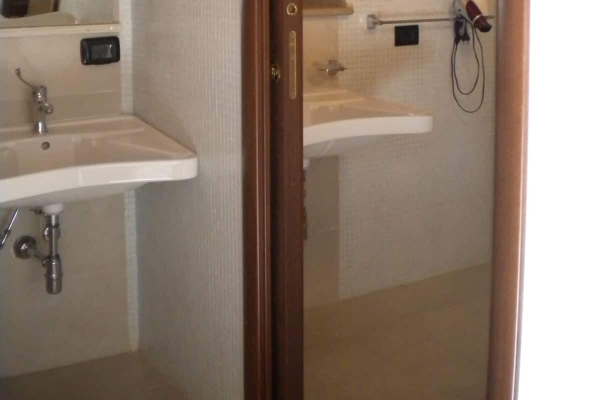 A bathroom with two sinks, a mirror, and a towel rack.