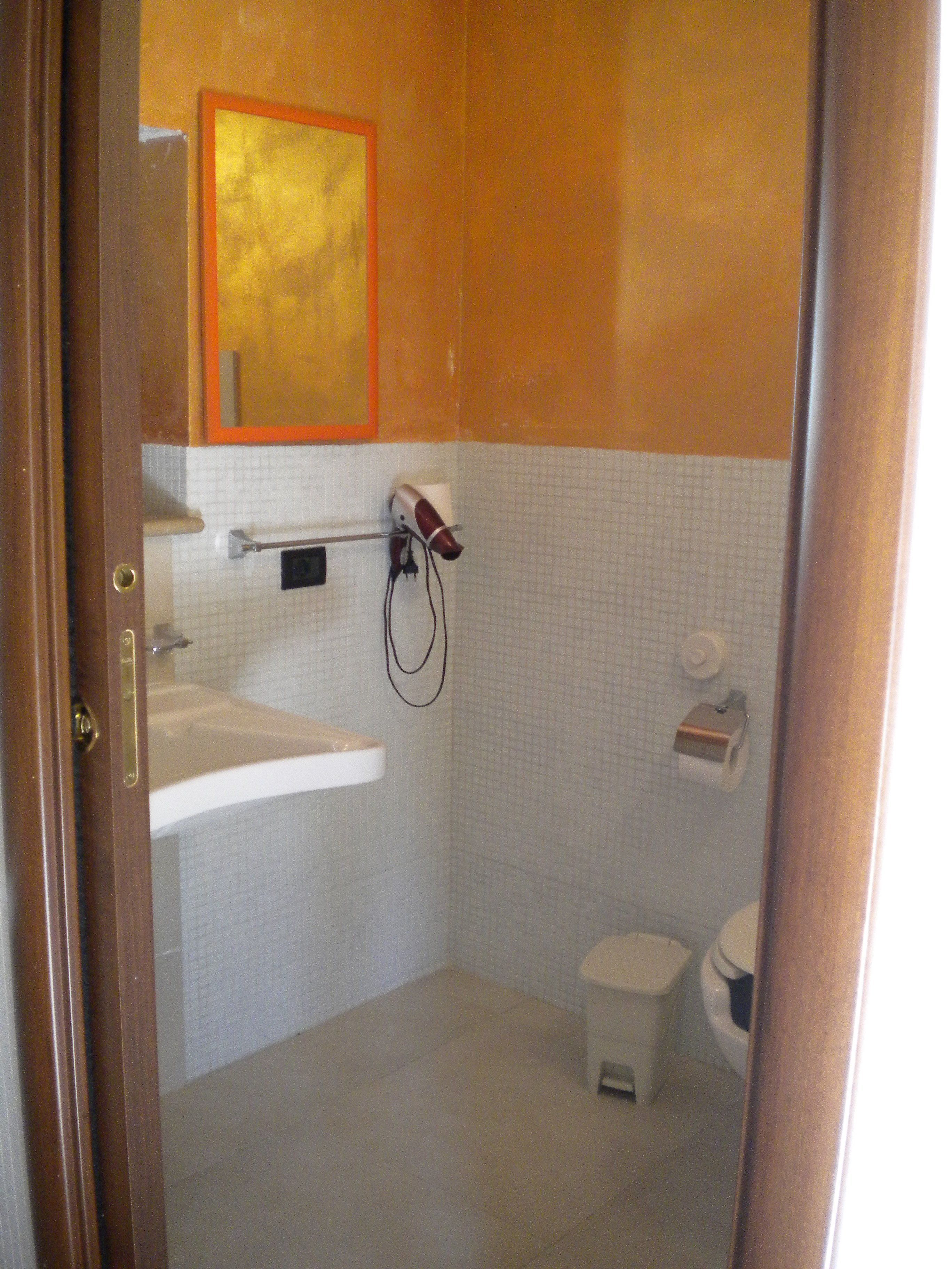 A bathroom with a white sink, a toilet, and a shower area.