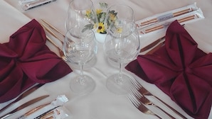 A long dining table set with red napkins, wine glasses, and cutlery. - Agriturismo Rifugio di Dedalo (Sant'Angelo Muxaro)