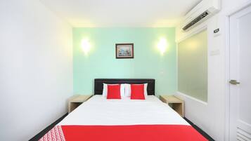 Habitación de hotel con cama, dos mesitas de noche, aire acondicionado de pared, un cuadro enmarcado y una puerta.