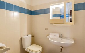 Ein Badezimmer mit Toilette, Waschbecken und Spiegel.