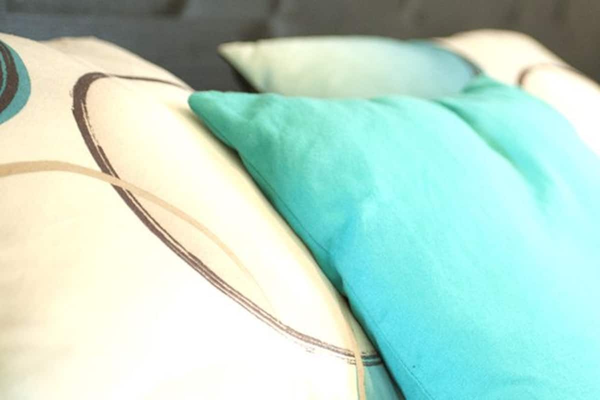 A close-up of a bed with multiple pillows, some with visible patterns.