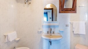 A bathroom with a sink, mirror, and towel rack.