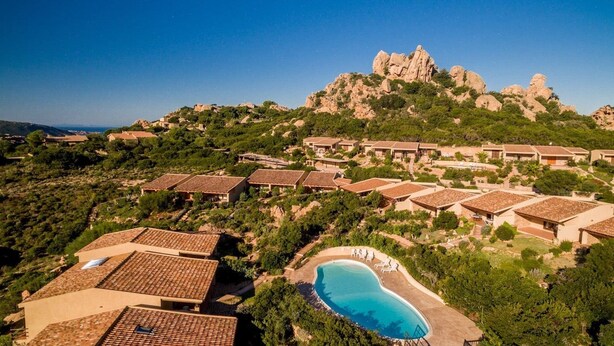 A resort with multiple villas, a swimming pool, and a mountainous backdrop. - Villetta Orchidea (Trinità d'Agultu e Vignola)