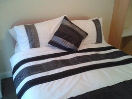 A bed with a striped bedspread and two pillows.