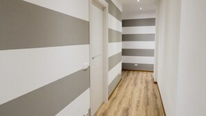 A hallway with striped walls and wooden flooring. - Suite Simonetta (Sarzana)
