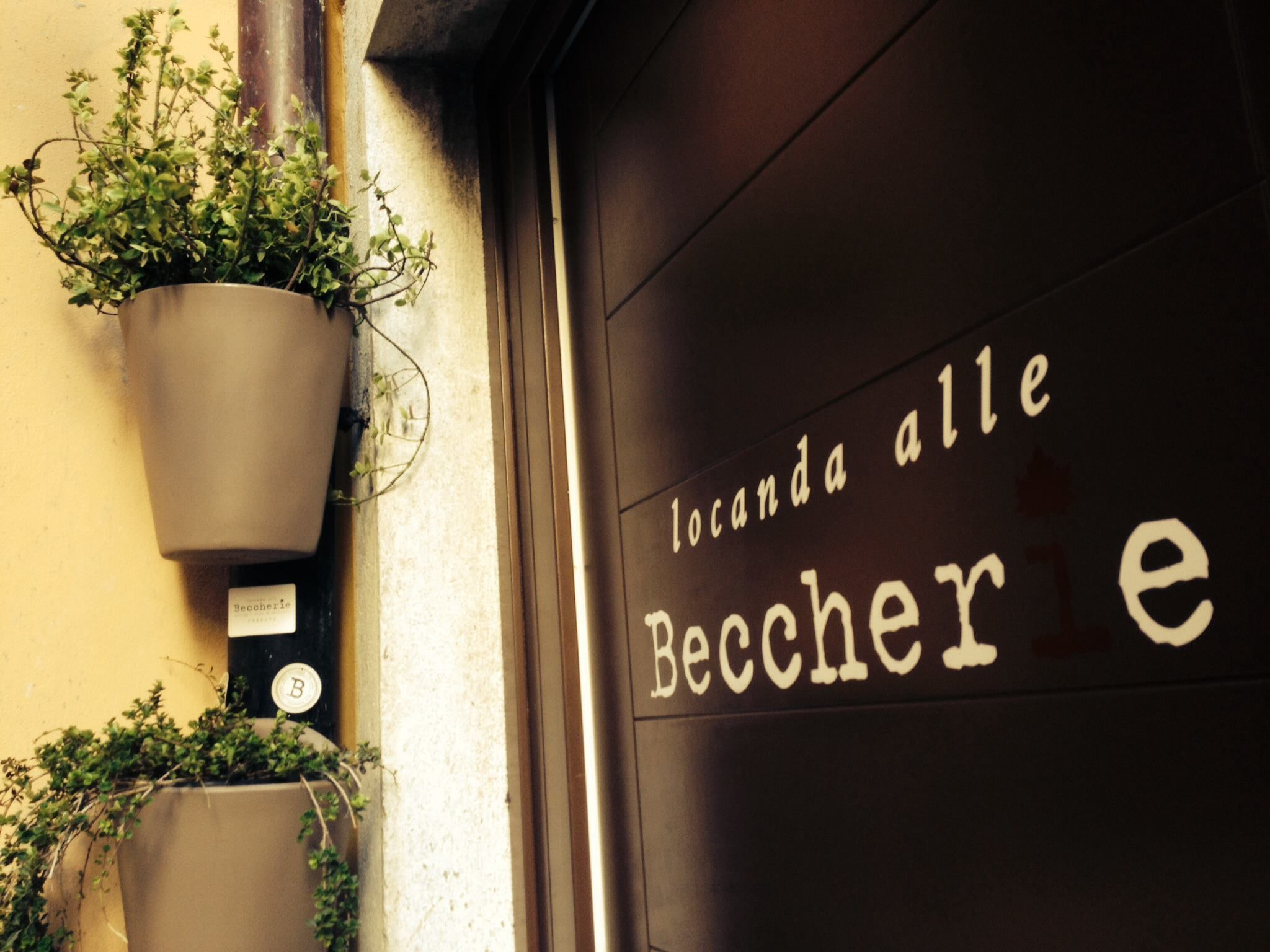 A door with the text "locanda alle Becher" indicating the name of the establishment.