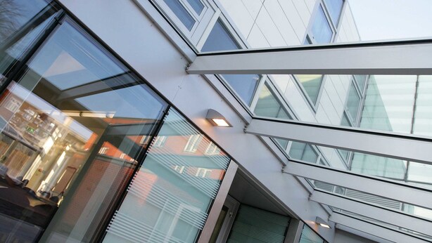 A modern building with large glass windows and a glass ceiling, allowing natural light to enter. - Davies Court - Hostel (London)