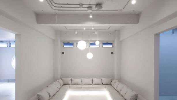 A modern conference room with a long table, white walls, and pendant lighting. - Tsukimi Hotel (Kyoto)