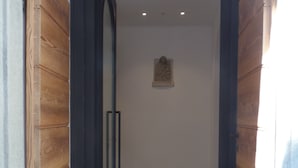 A hallway with wooden paneling and a black door. - Albergo Dongo (Dongo)
