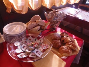 A breakfast buffet with pastries, croissants, and yogurt containers. - Albergo Dongo (Dongo)