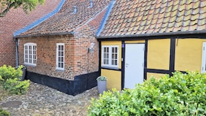 A traditional half-timbered house with a tiled roof, a white door, and a small window. - Hotel Town Living (Ringkobing)